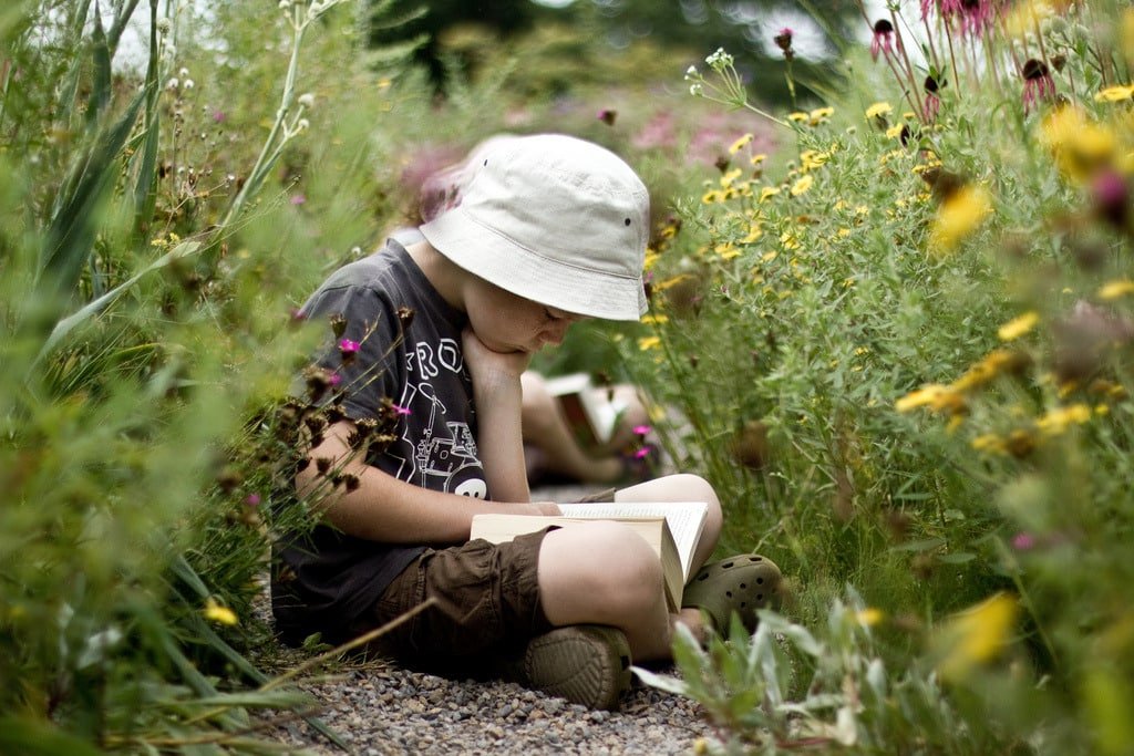 child reading in flowers