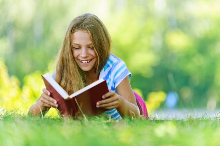 tween reading book outside